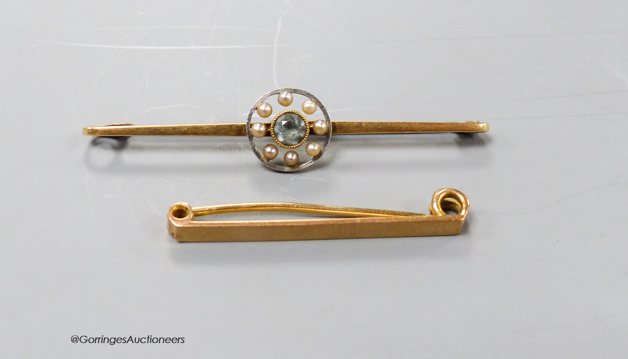 An Edwardian 15ct, aquamarine and seed pearl set bar brooch, 56mm, gross 3.5 grams and a 9ct bar brooch, 2 grams.